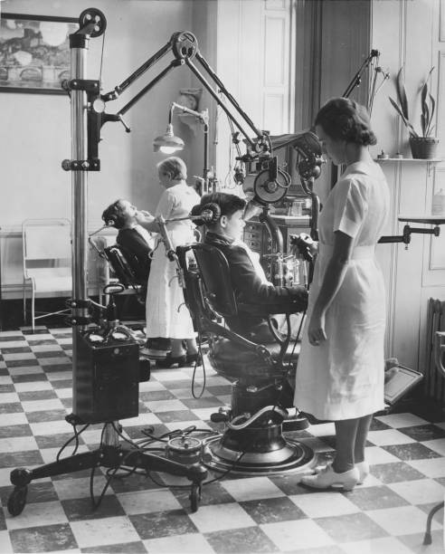 At an orphanage licensed dentists work with a pair of a patients New York New York 1920s or 1930s.