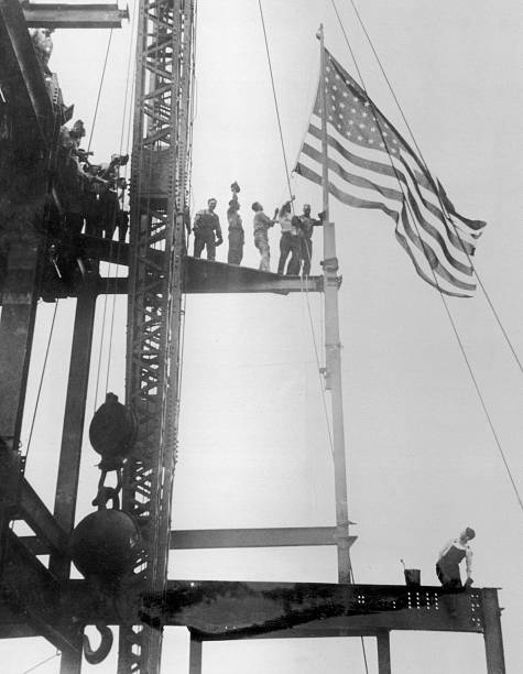 Construction workers celebrate the completion of the iron work on the Empire State Building Manhattan circa 1930. The building was constructed