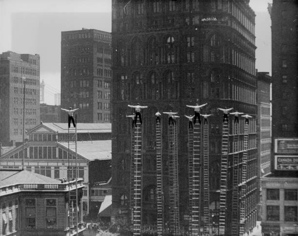 In lower Manhattan a group of rookie fire-fighters balance atop 85-foot ladders as part of their graduation skill demonstration New York New York