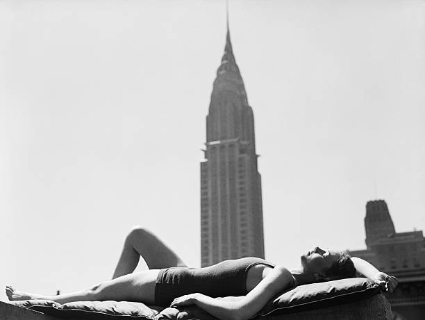 Woman sunbathing on a Manhattan roof near the Chrysler Building.