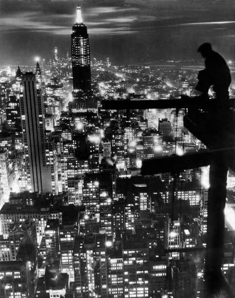 Workman pauses to admire the newly completed Empire State Building and the New York City skyline New York New York November 18 1932. The view is