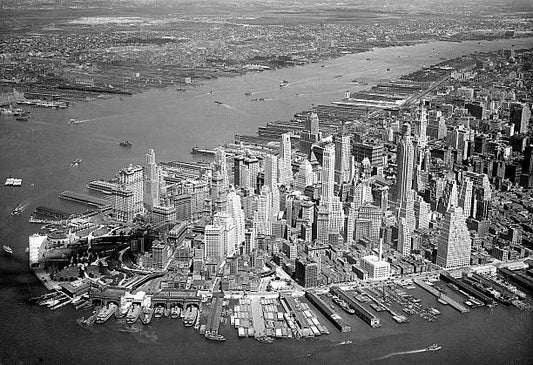 Air view of Manhattan taken from an elevation of 2000 feet with the Hudson River in the center dotted with tugs barges and ferries. Across the