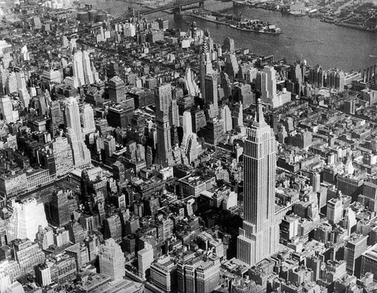 An aerial view of New York City showing the Empire State Building in the foreground and the Chrysler building.