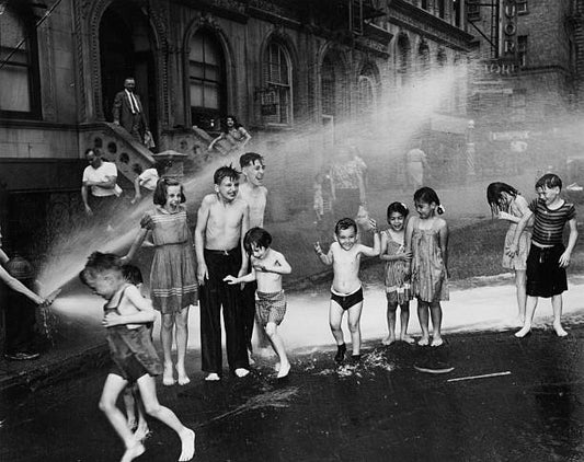 Children cool down in the spray from a fire hydrant during a hot summer on New York's Lower East Side.