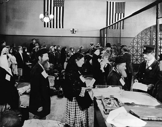 Crowd of immigrants possessions in tow patiently wait in line to meet with officials upon their arrival in America at Ellis Island New York New