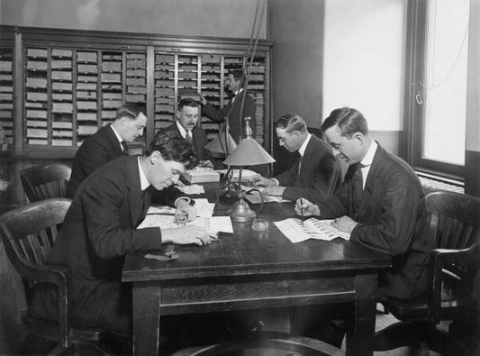 Fingerprint experts examining records and checking them with prints found at scenes of crime at New York Police Department's Bureau of Criminal