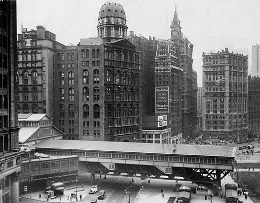 Manhattan passenger terminal of Brooklyn Bridge which crosses Park Row before it was removed to improve appearance of City Hall Park. At left center