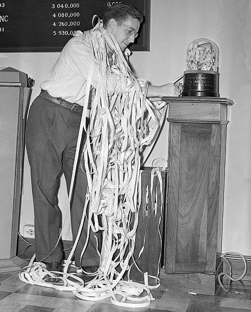 New York New York- An employee in a New York City brokerage house get all tangled up in ticker tape during the wild day in Wall Street when stock