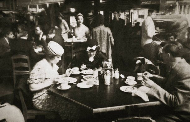 Office workers lunching in a restaurant New York USA early 1930s. The reflection of car can be seen in the window.