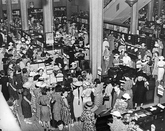 Overhead view of a crowd of male and female shoppers examining and purchasing goods during a summer sale at Macy's Department Store New York City.