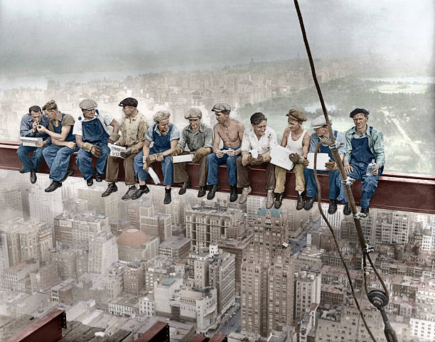 Sep 1932 Manhattan New York City New York State USA --- Construction workers eat their lunches atop a steel beam 800 feet above ground at the