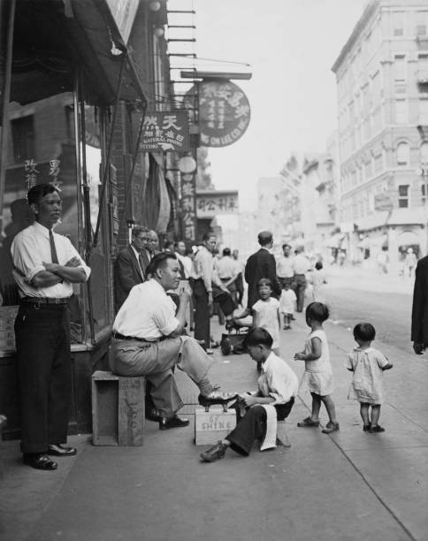 Shoeshine boy working on Mott Street in the Chinatown neighborhood of Lower Manhattan New York City 22nd September 1935.
