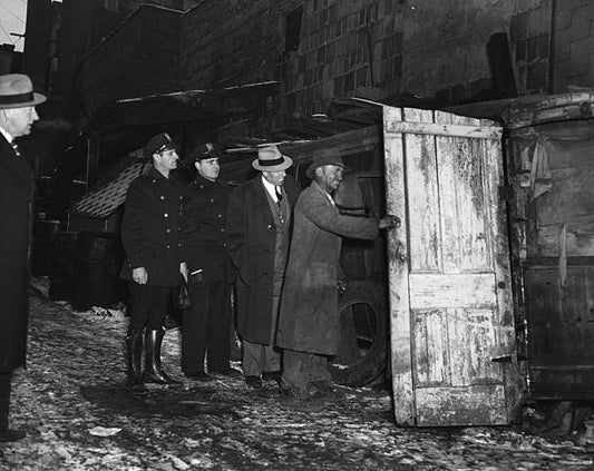 The owner of a shack made from a scrapped bus opens his door for Director Brady of the Newark Department of Public Affairs and Health Officials in