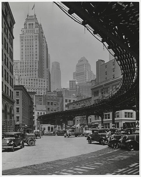 View beneath the S-curve of the El at Coenties Slip. A number of skyscrapers can be seen in the distance including the International Telephone and