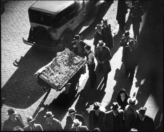 View from above of pedestrian traffic and a street cart vendor on the Lower East Side New York 1930.