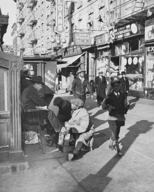 View of Lenox Avenue Harlem New York at 135th Street showing businesses pedestrians and shoe-shine stand March 23 1939. .