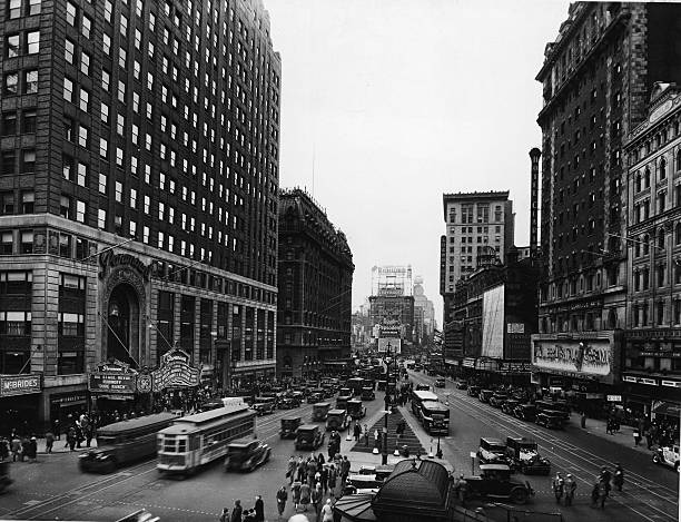 View of pedestrian and street traffic at Times Square from at the intersection of Broadway and 43rd Street New York New York 1932. The marquee of