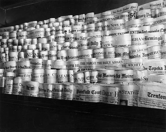 View of rows of newspapers from various American cities sitting in the racks of a newsstand Times Square New York City.